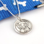 Golden Retriever Wax Seal Inspired Necklace shown next to a blue and white dog leash