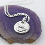 Fine silver ASL I Love You Symbol Token Charm Necklace shown on a sterling ball chain laying on a purple colored geode slice.