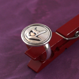 ASL I Love You Symbol Wax Seal Inspired Ring held up in a red clothespin on a purple background