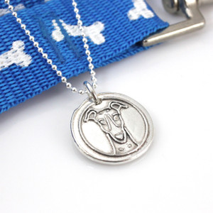 Greyhound or Whippet Wax Seal Inspired Necklace laying with a blue leash