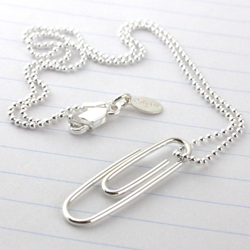 Handmade Sterling Silver Paper Clip Necklace on a ball chain laying on binder paper