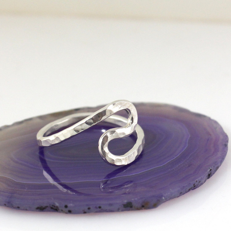 Size 9 Sterling silver Rustic Wave Ring shown setting on a purple flat surface