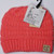 Product photo of the KIDS C.C MESSY BUN BEANIE CORAL baby beanie hat, showing the soft knit fabric, color, and pom pom detail, available at Forever And Always Online.