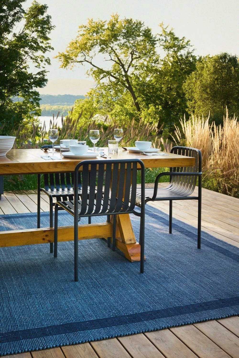 Blue performance indoor/outdoor rug under a dining table on a deck