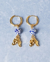 Gouden oorbellen met een bedeltje van een paar klompen en handbeschilderde Delfts blauwe kralen, van Heinen Delfts Blauw