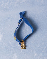 Elastieken armband met goudkleurig bedeltje van een kuspaartje van Heinen Delfts Blauw