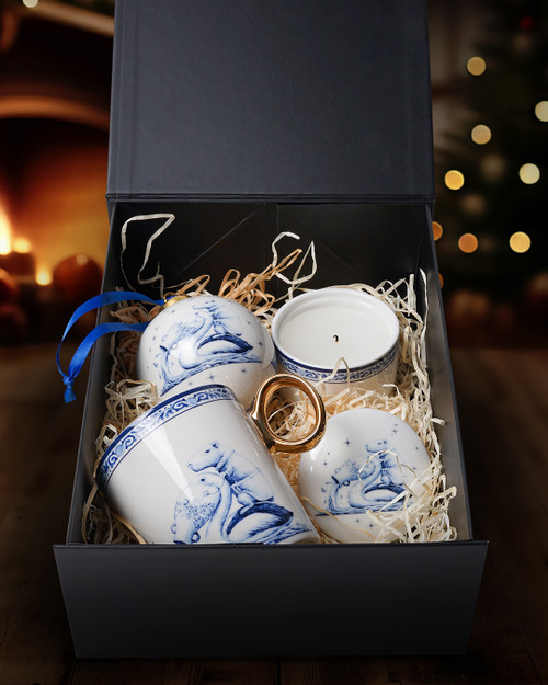 Een Delfts blauw cadeaupakket met drie producten uit de Zodiak collectie Waterman van Heinen Delfts Blauw, zoals een mok met een gouden oortje, een keramieken kaarsenbakje en een grote kerstbal.