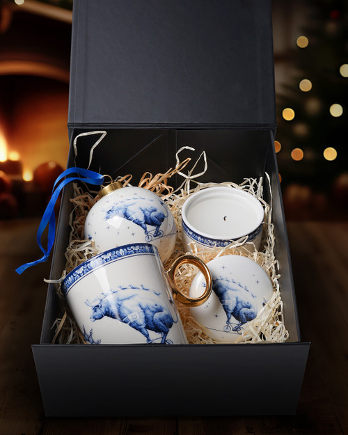 Een Delfts blauw cadeaupakket met drie producten uit de Zodiak collectie Stier van Heinen Delfts Blauw, zoals een mok met een gouden oortje, een keramieken kaarsenbakje en een grote kerstbal.