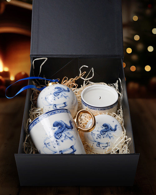 Een Delfts blauw cadeaupakket met drie producten uit de Zodiak collectie Ram van Heinen Delfts Blauw, zoals een mok met een gouden oortje, een keramieken kaarsenbakje en een grote kerstbal.