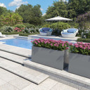Brisbane extra large fiberglass planter boxes in light gray finish with pink flowers beside swimming pool