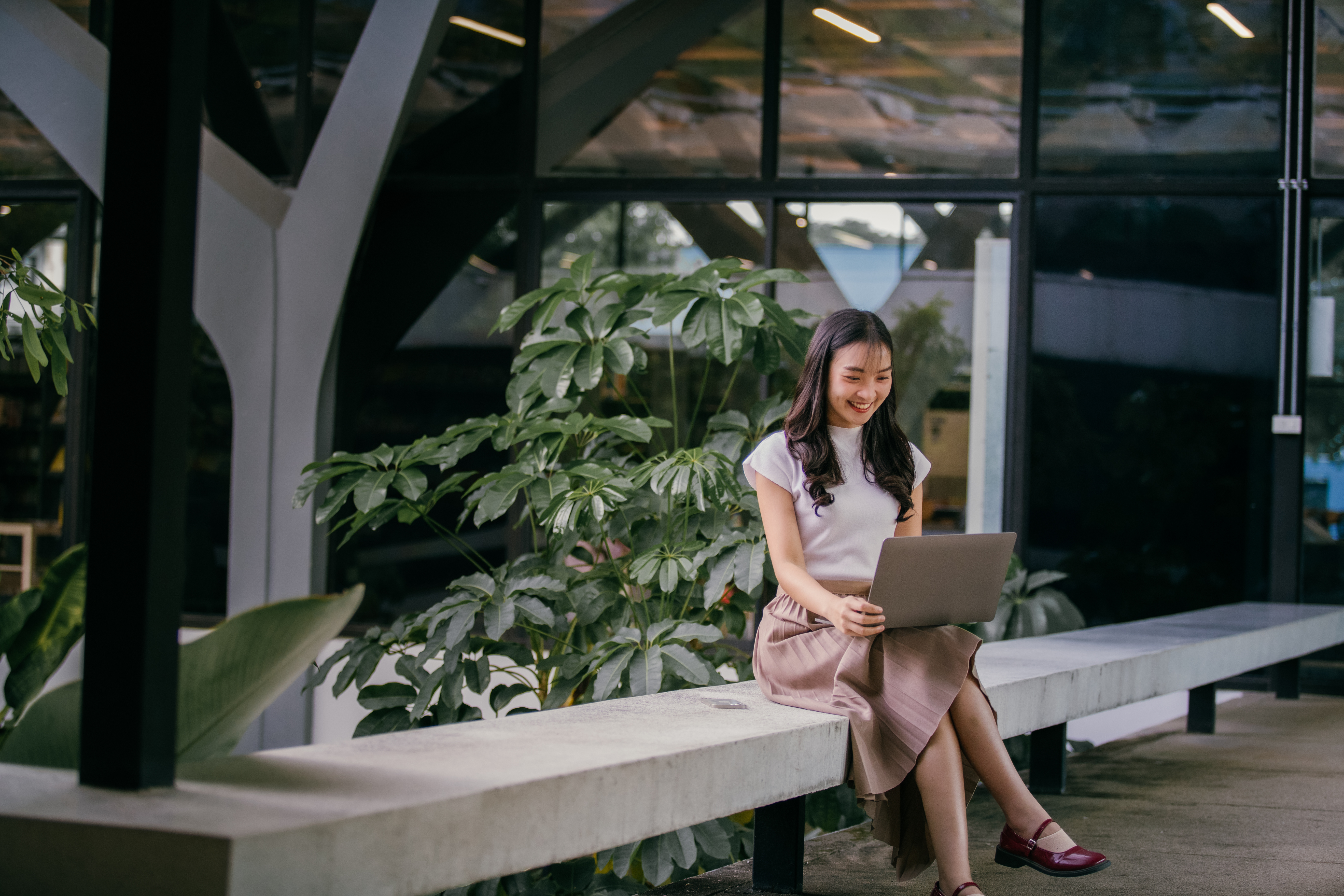 An employee working on her laptop in a modern green office