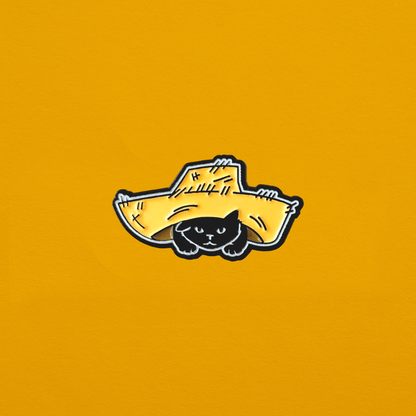 Soft enamel pin a black cat with a pava (a traditional wide brimmed straw hat worn by Puerto Rican jíbaros) that is to large for its head