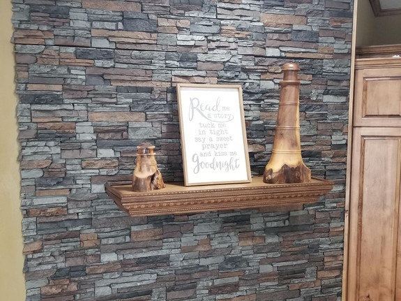 Living room wall paneled with our Denver Dry Stack Stone Wall panels in the oxford gray color.