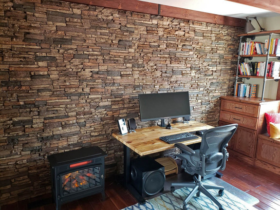Home office wall decorated with our Denver Dry Stack Stone Wall panels in the sienna color.