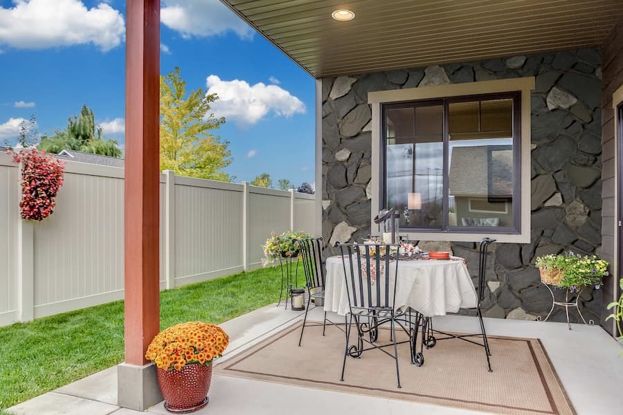 Small dining patio featuring Sardis Fieldstone Faux Stone Wall Panel in Volcano.