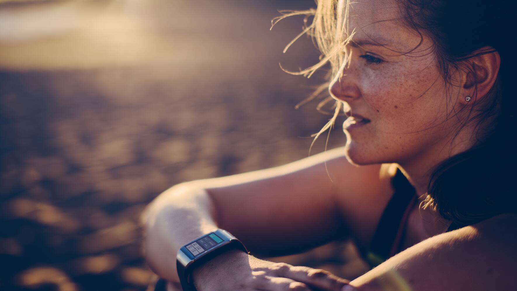 Woman watches the horizon with a smart watch on