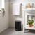 Black pedal bin in modern bathroom setting, placed beside white sink unit
