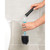 Refillable toilet brush handle being filled with blue cleaning liquid