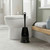 Black toilet brush and holder in modern bathroom setting