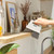 Hand using grey shelf brush to clean wooden shelf in kitchen