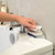 Grey multipurpose bathroom scrubbing brush in packaging, 4-in-1 for deep cleaning.