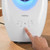White Beldray air purifier with touch controls, hand pressing on/off button