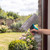 Hand using spray window cleaner with grey microfibre pad on glass