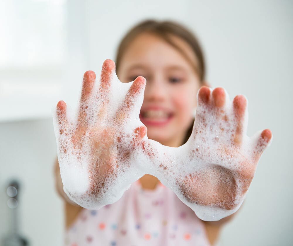 Girl with soap suds all over her hands