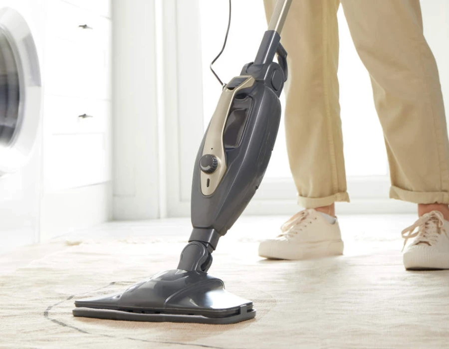 14-in-1 Steam Cleaner being used to clean hard flooring in a laundry room.