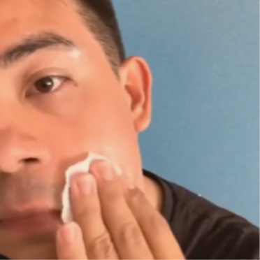A man wipes his cheek with a Complexion Treatment Pad.