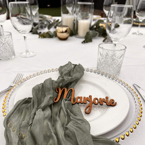 Laser cut blackwood timber plywood wedding guest name card styled on a plate with napkin. Laser cut blackwood timber plywood wedding guest name card styled on a plate with napkin.