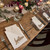 Laser cut walnut timber guest name cut outs acting as place cards for wedding seating.