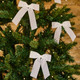 A pack of 6 White Velvet Bow Clip Decorations.