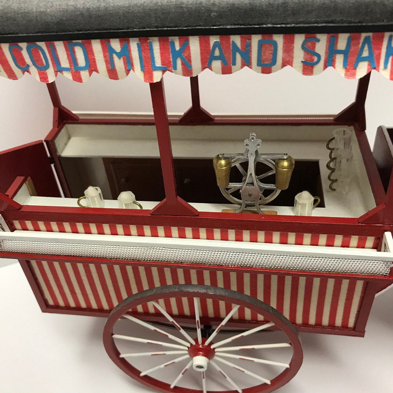 One-inch (1:12) scale dollhouse miniature ice cream wagon (circa 1895) looking in at counter