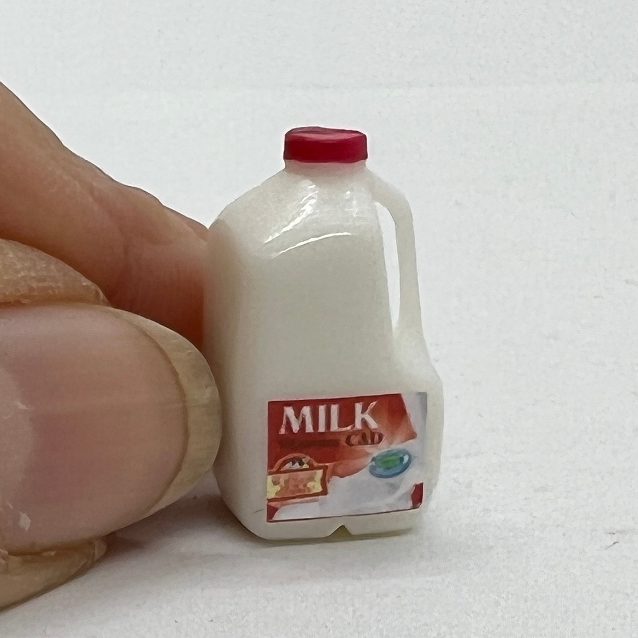 Milk, Gallon (CIMIG102) with fingers for scale