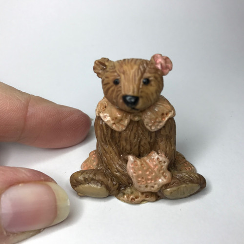Itty bitty brown bear with lacy collar and blanket
