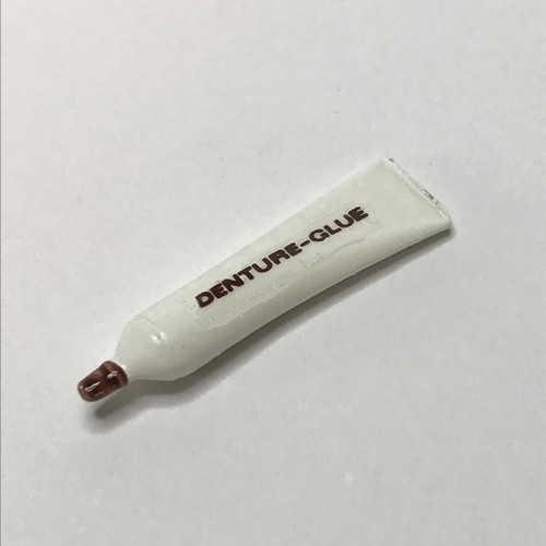 Miniature tube of denture adhesive