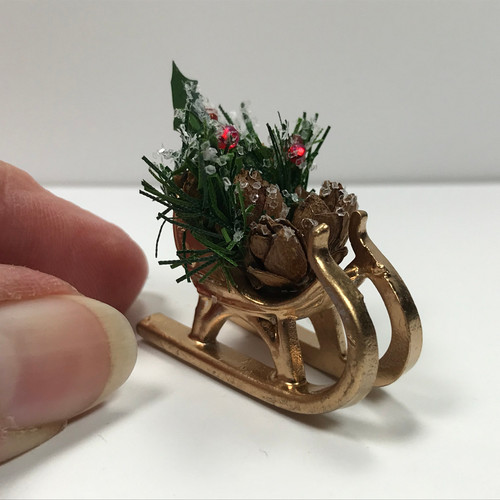 Tiny Sleigh Holiday Decoration (SMSSC713) with hand for scale