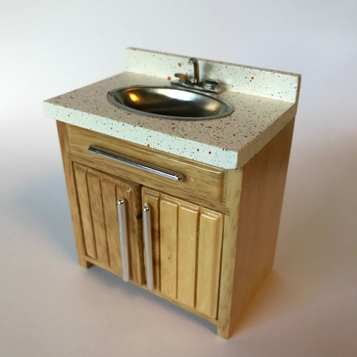 Sink with spatter countertop and oak stained panel cabinet