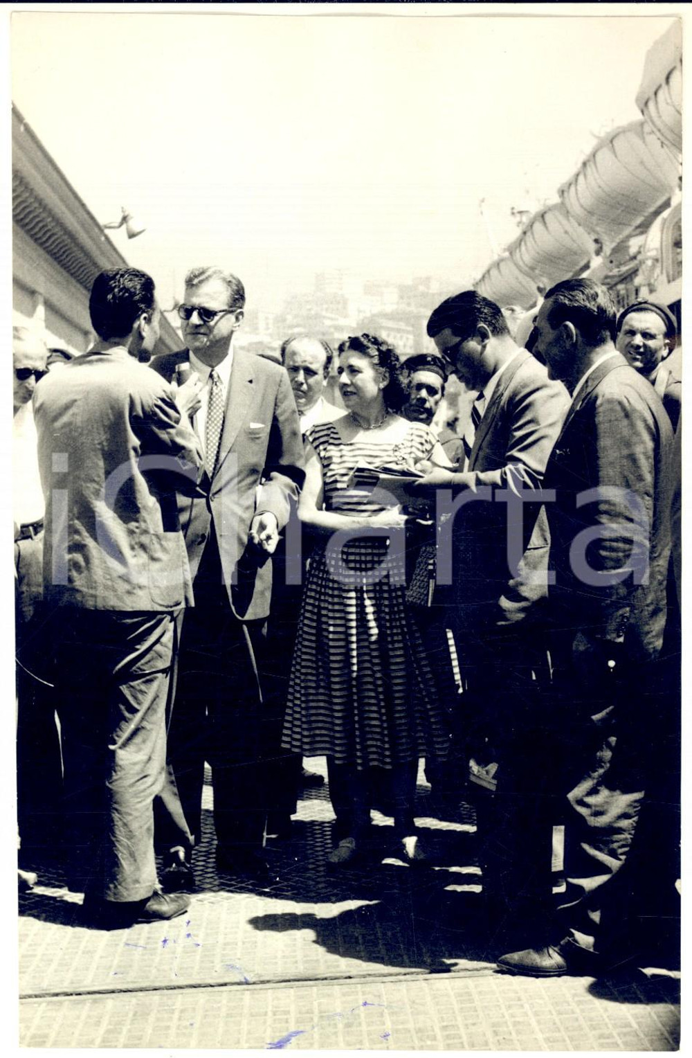 1957 GENOVA Joseph KESSEL in partenza con la moglie *Foto 13x18 cm Fotografia d'epoca con didascalia coeva. CONDIZIONI: POOR (lievi ondulature e graffi superficiali; macchie di inchiostro al margine inferiore) FORMATO: 13x18 cm     originale e autentica 1