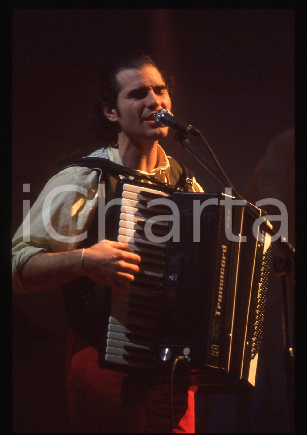 35mm vintage slide*1990ca Francesco BACCINI con fisarmonica Transicord   Diapositiva d'epoca, in formato 35 mm. CONDIZIONI: GOODE' severamente vietata la riproduzione. Tutti i diritti sono riservati. ICharta mette in vendita, sul negozio eBay e in esclusiva sul sito "icharta" il proprio archivio composto da numerose diapositive e negativi fotografici d'epoca, tutti originali e autentici, che attraversano la storia del costume italiano tra gli la fine degli anni Sessanta e Novanta.Si tratta di uno sguardo inedito sull'attualit&agrave;, la politica, la vita quotidiana, il gossip e la cultura, che fotografa il cambiamento della nazione in quest'ultimo scorcio del XX secolo. Un'occasione unica per il mercato del collezionismo, che vede finalmente disponibile un archivio eccezionale per vastit&agrave;, tematiche e condizioni, in un settore (il negativo fotografico e la diapositiva) di assoluta novit&agrave; e dalle interessanti prospettive di investimento.  originale e autentica 1