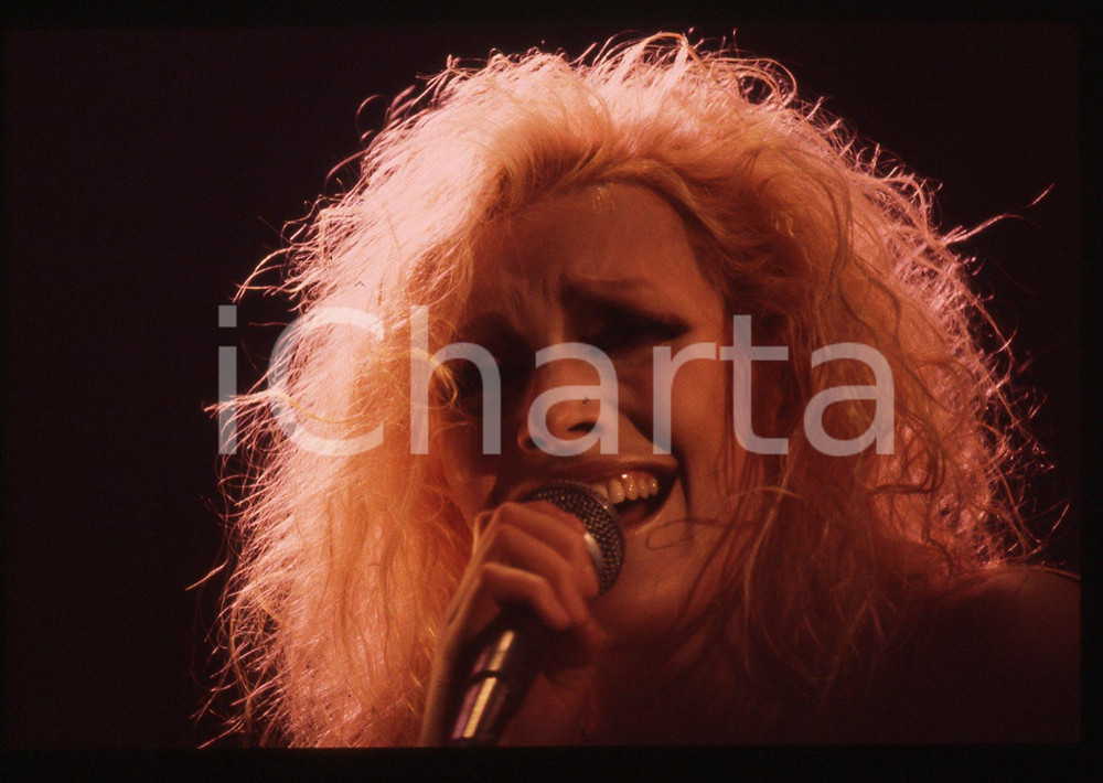 35mm vintage slide* 1990ca Anna OXA ritratto della cantante in concerto   Diapositiva d'epoca, in formato 35 mm. CONDIZIONI: GOODE' severamente vietata la riproduzione. Tutti i diritti sono riservati. ICharta mette in vendita, sul negozio eBay e in esclusiva sul sito "icharta" il proprio archivio composto da numerose diapositive e negativi fotografici d'epoca, tutti originali e autentici, che attraversano la storia del costume italiano tra gli la fine degli anni Sessanta e Novanta.Si tratta di uno sguardo inedito sull'attualit&agrave;, la politica, la vita quotidiana, il gossip e la cultura, che fotografa il cambiamento della nazione in quest'ultimo scorcio del XX secolo. Un'occasione unica per il mercato del collezionismo, che vede finalmente disponibile un archivio eccezionale per vastit&agrave;, tematiche e condizioni, in un settore (il negativo fotografico e la diapositiva) di assoluta novit&agrave; e dalle interessanti prospettive di investimento.     originale e autentica 1