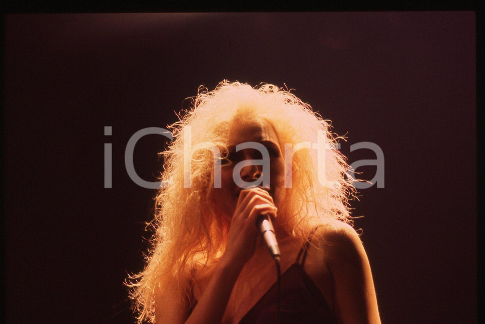 35mm vintage slide* 1990ca Anna OXA ritratto della cantante in concerto (2)   Diapositiva d'epoca, in formato 35 mm. CONDIZIONI: GOODE' severamente vietata la riproduzione. Tutti i diritti sono riservati. ICharta mette in vendita, sul negozio eBay e in esclusiva sul sito "icharta" il proprio archivio composto da numerose diapositive e negativi fotografici d'epoca, tutti originali e autentici, che attraversano la storia del costume italiano tra gli la fine degli anni Sessanta e Novanta.Si tratta di uno sguardo inedito sull'attualit&agrave;, la politica, la vita quotidiana, il gossip e la cultura, che fotografa il cambiamento della nazione in quest'ultimo scorcio del XX secolo. Un'occasione unica per il mercato del collezionismo, che vede finalmente disponibile un archivio eccezionale per vastit&agrave;, tematiche e condizioni, in un settore (il negativo fotografico e la diapositiva) di assoluta novit&agrave; e dalle interessanti prospettive di investimento.     originale e autentica 1