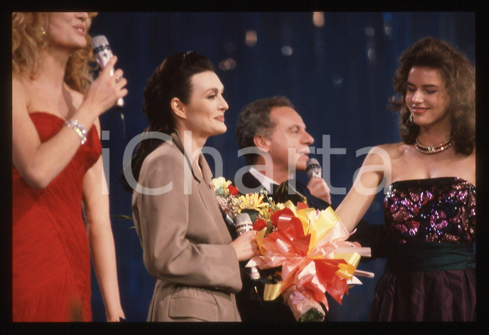 35mm vintage slide* 1990 SANREMO Anna OXA Gabriella CARLUCCI Johnny DORELLI   Diapositiva d'epoca, in formato 35 mm. CONDIZIONI: GOODE' severamente vietata la riproduzione. Tutti i diritti sono riservati. ICharta mette in vendita, sul negozio eBay e in esclusiva sul sito "icharta" il proprio archivio composto da numerose diapositive e negativi fotografici d'epoca, tutti originali e autentici, che attraversano la storia del costume italiano tra gli la fine degli anni Sessanta e Novanta.Si tratta di uno sguardo inedito sull'attualit&agrave;, la politica, la vita quotidiana, il gossip e la cultura, che fotografa il cambiamento della nazione in quest'ultimo scorcio del XX secolo. Un'occasione unica per il mercato del collezionismo, che vede finalmente disponibile un archivio eccezionale per vastit&agrave;, tematiche e condizioni, in un settore (il negativo fotografico e la diapositiva) di assoluta novit&agrave; e dalle interessanti prospettive di investimento.     originale e autentica 1