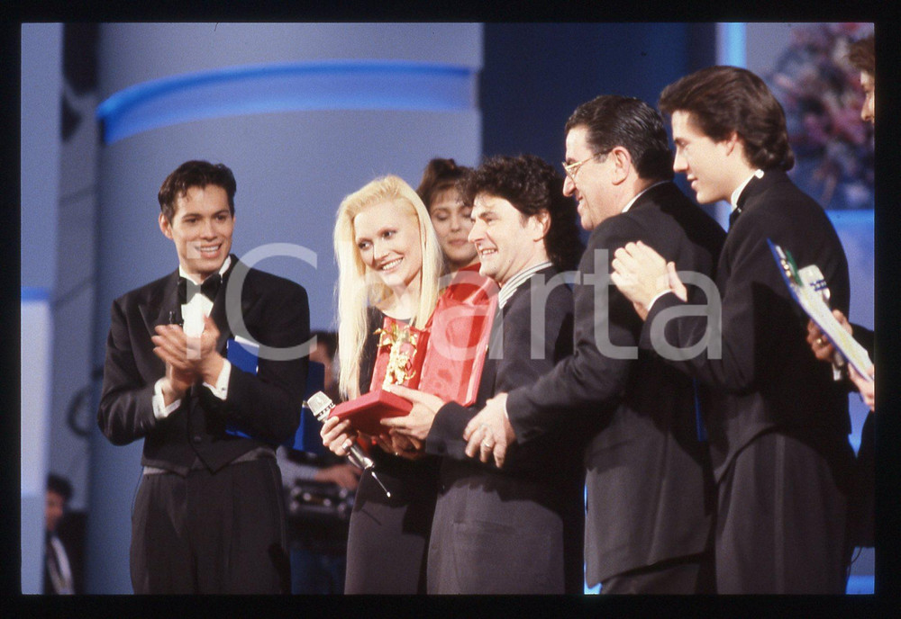 35mm vintage slide* 1989 Festival SANREMO Anna OXA Fausto LEALI Danny QUINN   Diapositiva d'epoca, in formato 35 mm. CONDIZIONI: GOODE' severamente vietata la riproduzione. Tutti i diritti sono riservati. ICharta mette in vendita, sul negozio eBay e in esclusiva sul sito "icharta" il proprio archivio composto da numerose diapositive e negativi fotografici d'epoca, tutti originali e autentici, che attraversano la storia del costume italiano tra gli la fine degli anni Sessanta e Novanta.Si tratta di uno sguardo inedito sull'attualit&agrave;, la politica, la vita quotidiana, il gossip e la cultura, che fotografa il cambiamento della nazione in quest'ultimo scorcio del XX secolo. Un'occasione unica per il mercato del collezionismo, che vede finalmente disponibile un archivio eccezionale per vastit&agrave;, tematiche e condizioni, in un settore (il negativo fotografico e la diapositiva) di assoluta novit&agrave; e dalle interessanti prospettive di investimento.     originale e autentica 1