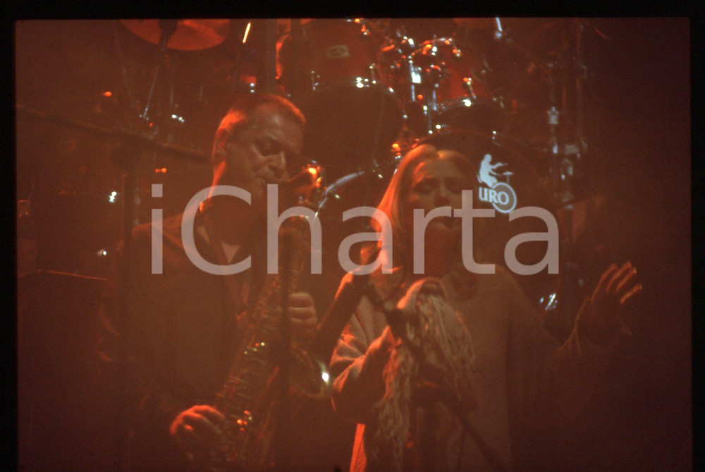 35mm vintage slide* 1990ca Anna OXA con sassofonista in concerto (4)   Diapositiva d'epoca, in formato 35 mm. CONDIZIONI: GOODE' severamente vietata la riproduzione. Tutti i diritti sono riservati. ICharta mette in vendita, sul negozio eBay e in esclusiva sul sito "icharta" il proprio archivio composto da numerose diapositive e negativi fotografici d'epoca, tutti originali e autentici, che attraversano la storia del costume italiano tra gli la fine degli anni Sessanta e Novanta.Si tratta di uno sguardo inedito sull'attualit&agrave;, la politica, la vita quotidiana, il gossip e la cultura, che fotografa il cambiamento della nazione in quest'ultimo scorcio del XX secolo. Un'occasione unica per il mercato del collezionismo, che vede finalmente disponibile un archivio eccezionale per vastit&agrave;, tematiche e condizioni, in un settore (il negativo fotografico e la diapositiva) di assoluta novit&agrave; e dalle interessanti prospettive di investimento.     originale e autentica 1