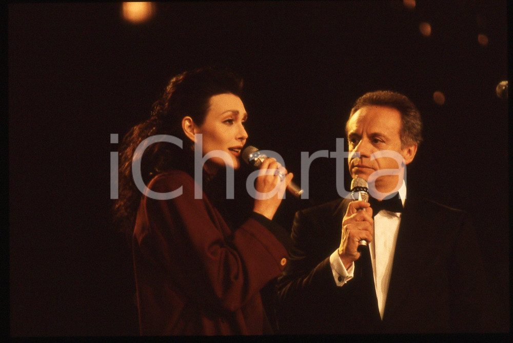 35mm vintage slide* 1990 Festival di SANREMO Anna OXA con Johnny DORELLI   Diapositiva d'epoca, in formato 35 mm. CONDIZIONI: GOODE' severamente vietata la riproduzione. Tutti i diritti sono riservati. ICharta mette in vendita, sul negozio eBay e in esclusiva sul sito "icharta" il proprio archivio composto da numerose diapositive e negativi fotografici d'epoca, tutti originali e autentici, che attraversano la storia del costume italiano tra gli la fine degli anni Sessanta e Novanta.Si tratta di uno sguardo inedito sull'attualit&agrave;, la politica, la vita quotidiana, il gossip e la cultura, che fotografa il cambiamento della nazione in quest'ultimo scorcio del XX secolo. Un'occasione unica per il mercato del collezionismo, che vede finalmente disponibile un archivio eccezionale per vastit&agrave;, tematiche e condizioni, in un settore (il negativo fotografico e la diapositiva) di assoluta novit&agrave; e dalle interessanti prospettive di investimento.     originale e autentica 1