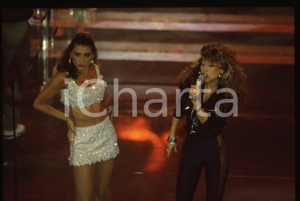 35mm vintage slide *1991 Festival di SANREMO Sabrina SALERNO e Jo SQUILLO (5)   Diapositiva d'epoca, in formato 35 mm.  CONDIZIONI: GOOD E' severamente vietata la riproduzione. Tutti i diritti sono riservati. ICharta mette in vendita, sul negozio eBay e in esclusiva sul sito "icharta" il proprio archivio composto da numerose diapositive e negativi fotografici d'epoca, tutti originali e autentici, che attraversano la storia del costume italiano tra gli la fine degli anni Sessanta e Novanta.Si tratta di uno sguardo inedito sull'attualit&agrave;, la politica, la vita quotidiana, il gossip e la cultura, che fotografa il cambiamento della nazione in quest'ultimo scorcio del XX secolo. Un'occasione unica per il mercato del collezionismo, che vede finalmente disponibile un archivio eccezionale per vastit&agrave;, tematiche e condizioni, in un settore (il negativo fotografico e la diapositiva) di assoluta novit&agrave; e dalle interessanti prospettive di investimento.   originale e autentica 1