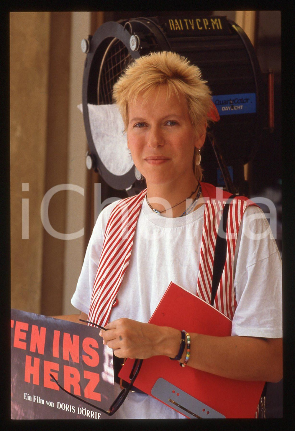 35mm vintage slide* 1983 Doris DORRIE con locandina film MITTEN INS HERZ   Diapositiva d'epoca, in formato 35 mm. CONDIZIONI: GOODE' severamente vietata la riproduzione. Tutti i diritti sono riservati. ICharta mette in vendita, sul negozio eBay e in esclusiva sul sito "icharta" il proprio archivio composto da numerose diapositive e negativi fotografici d'epoca, tutti originali e autentici, che attraversano la storia del costume italiano tra gli la fine degli anni Sessanta e Novanta.Si tratta di uno sguardo inedito sull'attualit&agrave;, la politica, la vita quotidiana, il gossip e la cultura, che fotografa il cambiamento della nazione in quest'ultimo scorcio del XX secolo. Un'occasione unica per il mercato del collezionismo, che vede finalmente disponibile un archivio eccezionale per vastit&agrave;, tematiche e condizioni, in un settore (il negativo fotografico e la diapositiva) di assoluta novit&agrave; e dalle interessanti prospettive di investimento.  originale e autentica 1