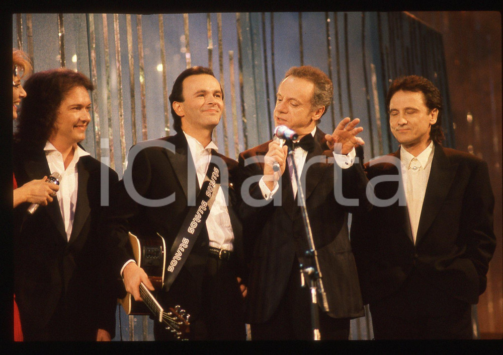 35mm vintage slide*1990 Festival SANREMO POOH Johnny DORELLI Gabriella CARLUCCI*   Diapositiva d'epoca, in formato 35 mm.Nella diapositiva i componenti del gruppo musicale POOH (Roby Facchinetti, Dodi Battaglia e Red Canzian) con Gabriella Carlucci e Johnny Dorelli sul palcoscenico del Festival di Sanremo del 1990. CONDIZIONI: GOODE' severamente vietata la riproduzione. Tutti i diritti sono riservati. ICharta mette in vendita, sul negozio eBay e in esclusiva sul sito "icharta" il proprio archivio composto da numerose diapositive e negativi fotografici d'epoca, tutti originali e autentici, che attraversano la storia del costume italiano tra gli la fine degli anni Sessanta e Novanta.Si tratta di uno sguardo inedito sull'attualit&agrave;, la politica, la vita quotidiana, il gossip e la cultura, che fotografa il cambiamento della nazione in quest'ultimo scorcio del XX secolo. Un'occasione unica per il mercato del collezionismo, che vede finalmente disponibile un archivio eccezionale per vastit&agrave;, tematiche e condizioni, in un settore (il negativo fotografico e la diapositiva) di assoluta novit&agrave; e dalle interessanti prospettive di investimento.  originale e autentica 1